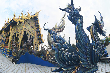 Fototapeta na wymiar The Naga Ladder Sculpture front of chapel is a unique applied art using shades of blue and sky contrasting with gold. Various patterns flow and are delicate. At Wat Rong Suea Ten temple. Thailand.