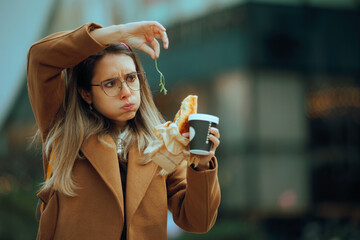 Woman Dislikes Finding a rocket salad in her Sandwich. Office worker having her breakfast in a rush...