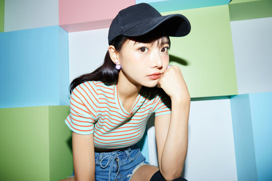 カラフルな背景で撮影をした若い女性のカジュアルなポートレート