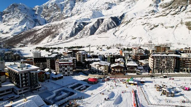 Panoramic aerial drone scenic view at ski slopes, mountain skiing and popular resort town. Italian ski resort in Alps in Aosta Valley in winter. Winter landscape. Italy, Breuil Cervinia. 4K video.