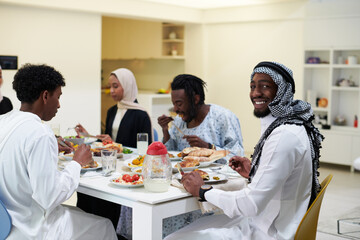 A traditional and diverse Muslim family comes together to share a delicious iftar meal during the sacred month of Ramadan, embodying the essence of familial joy, cultural richness, and spiritual unity
