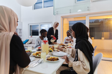 In the sacred month of Ramadan, a Muslim family joyously comes together around a table, eagerly...