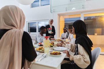 Fototapeta na wymiar In the sacred month of Ramadan, a Muslim family joyously comes together around a table, eagerly awaiting the communal iftar, engaging in the preparation of a shared meal, and uniting in anticipation