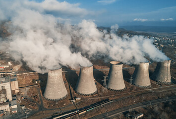 Aerial view of an industrial zone pipes pouring thick white smoke. Thick smoke plumes. Thermal power plant pipes, air pollution.
