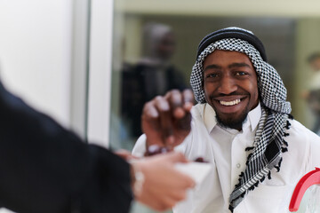 African American Muslim man delicately takes dates to break his fast during the Ramadan month,...