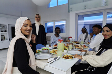 In the sacred month of Ramadan, a Muslim family joyously comes together around a table, eagerly awaiting the communal iftar, engaging in the preparation of a shared meal, and uniting in anticipation