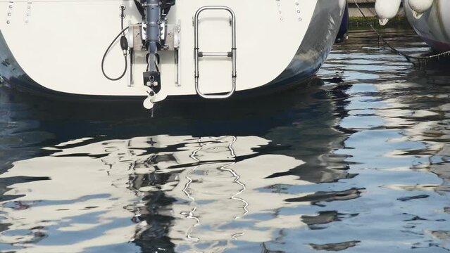  bottom view of the back of moored boats with outboard motor on the quay