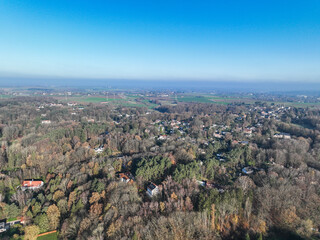 Aerial view of houses surrounded by forest and farmland in the country side area of Walloon, Belgium, Europe