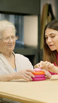 Nursing helping a senior woman to resolve a skill game