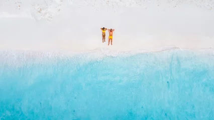 Fotobehang Drone top view of a couple of men and women lying down on the beach of Small Curacao Island, a couple relaxing on the beach of Curacao, top view at a tropical beach © Fokke Baarssen