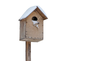Bird house hanging on a tree. Snow and frost on the roof. Caring for birds in winter.