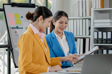 Fototapeta premium Confident female professional discussing with colleagues, Professional business executive managers working using laptop computer sitting at table, discussing digital strategy at corporate meeting.