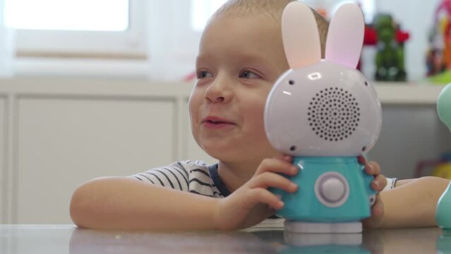 happy child playing with interactive musical toy smart bunny for children