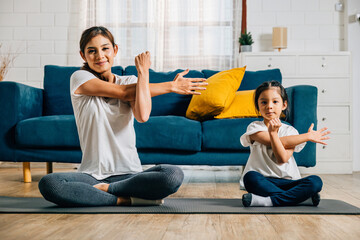 A mother and her daughter share a heartwarming gym session emphasizing stretching and yoga creating...