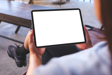 Mockup image of a woman holding digital tablet with blank white desktop screen in cafe