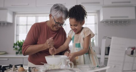 Baking and cooking with a grandmother and her granddaughter during a visit at home for bonding and spending quality time together. Grandparent teaching her grandchild how to bake in the kitchen - Powered by Adobe