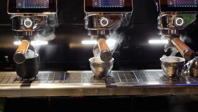 coffee making machine in coffee shop pouring hot coffee with steam