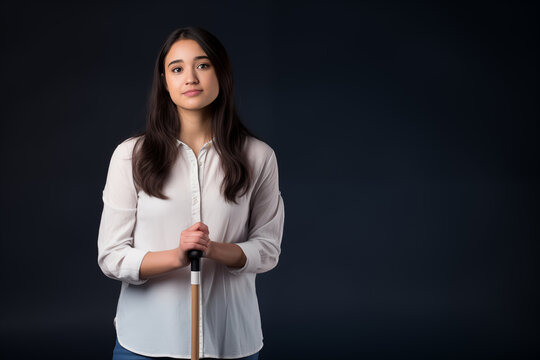 young woman holding walking stick, isolated on black studio background with copy space 