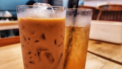 Iced coffee on wood table in coffee shop. Selective focus.