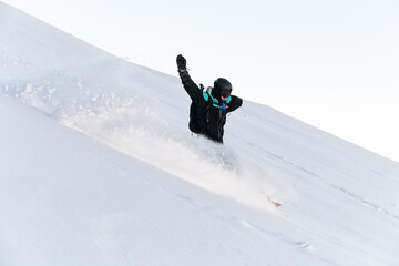 One-armed male skier in a blue ski suit is going down a snowy slope