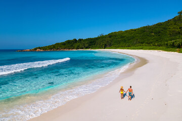 Fototapeta na wymiar Anse Cocos beach La Digue Island Seychelles, Drone aerial view of La Digue Seychelles bird eye view of a tropical Island, a couple men and woman walking at the beach during sunset at a luxury vacation