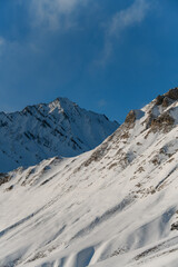 Snow-covered slopes merge with the blue clear sky