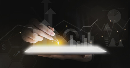 A person holds a tablet and pen to write on the screen, graphic charts and fluctuations in financial data, showing business growth. Business strategy. Digital marketing. digital business hologram.