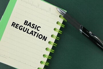 pen and book with the word basic regulation. concept of basic rules that need to be done