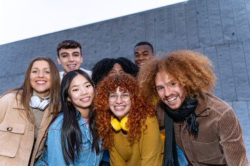 Group of young multiethnic friends smiling while posing together outdoors. Friendship concept.