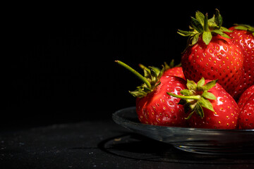 Red ripe strawberries on a black background, strawberries for dessert