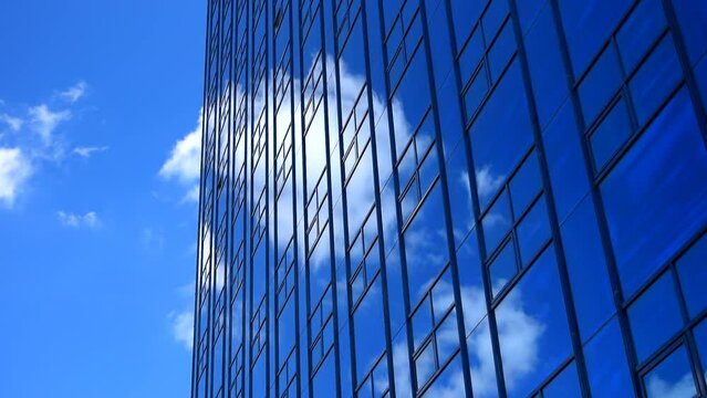 Tall big office building with white clouds, blue clean sky background. Time lapse, tower, highrise, facade, high, estate, center, glass, glazed, windows, place, city, wall, cloud, hd. ProRes 422 HQ.