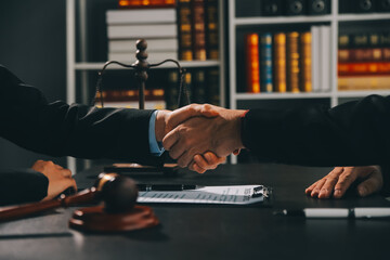 Businessman shaking hands to seal a deal with his partner lawyers or attorneys discussing a contract agreement - obrazy, fototapety, plakaty