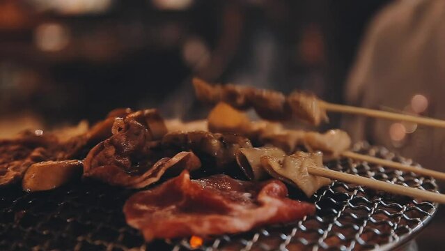 Party for barbecue japanese style, yakiniku. Meats are being cooked on stove in a japanese