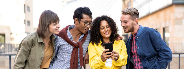 Horizontal banner or header with multicultural friends having fun with mobile phone at campus college yard - Young guys spending time sharing funny video on cell device - Focus on colombian curly girl - obrazy, fototapety, plakaty