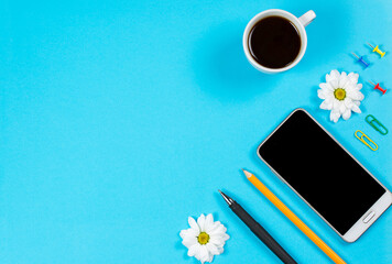 Office stationery and mobile phone on a blue background, office stationery