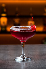 Manhattan cocktail with red vermouth, vodka, bitters, cherries and ice in a glass.