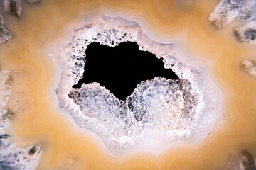 quartz druse at the center of an agate macro detail texture background. close-up raw rough...