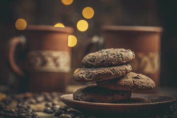Beautiful mug with coffee and chocolate cookies on a beautiful background, holiday treats