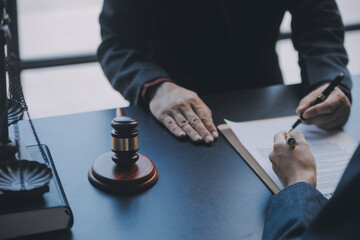 Business and lawyers discussing contract papers with brass scale on desk in office. Law, legal services, advice, justice and law concept picture with film grain effect