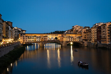 Ponte Vecchio in Florence, Italy at sundown as people prepare for Fochi di San Giovanni - obrazy, fototapety, plakaty