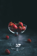 Healthy love concept, strawberry fruit on glass, black background.
