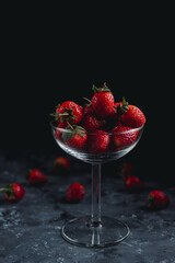 Healthy love concept, strawberry fruit on glass, black background.
