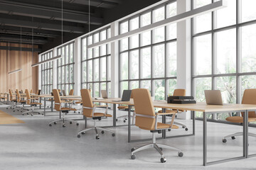 Cozy workspace interior with furniture, laptop on desk in row, panoramic window