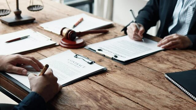 Attorney gives the client a pen to sign a contract admitting fraud, lawyer admits a fraud case in which client is a victim and will sue defendant who is a commercial partner. Fraud litigation concept.