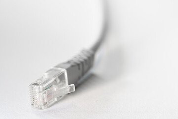 Close-up macro shot of a white RJ45 Ethernet cable on a white table with copy space