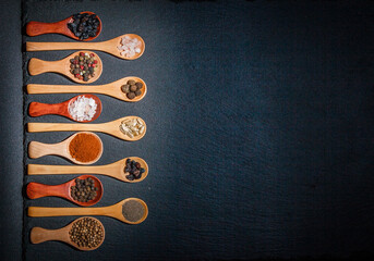 All types of spices on a black background, different spices in spoons on a black background,...