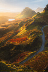 Vibrant golden light over epic mountain landscape of the rugged, contoured terrain of the Cleat at the Quiraing on the Isle of Skye, Scotland.