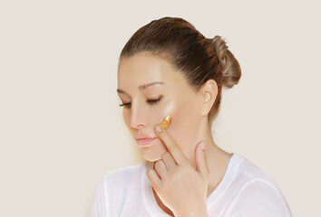 woman applying serum, lotion to her face