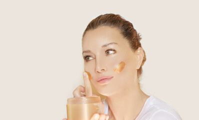 woman applying serum, lotion to her face