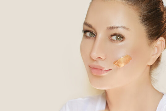 woman applying serum, lotion to her face